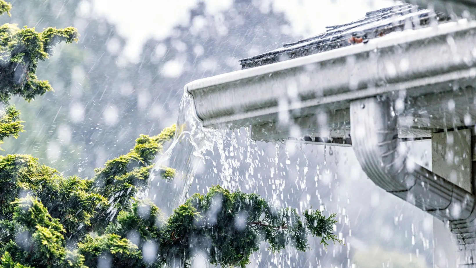 A residential gutter during a heavy storm, with rainwater flowing through, highlighting the importance of proper drainage. Empire Contractors LLC provides expert gutter installation, cleaning, and maintenance services in Cincinnati, OH, and surrounding areas to protect homes from water damage.