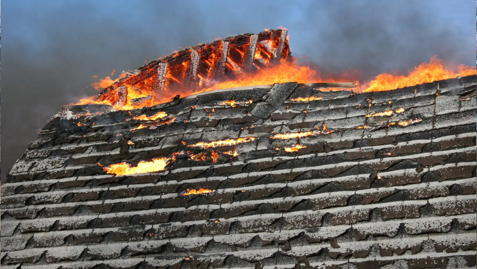 A residential roof with visible fire damage, including charred shingles and structural deterioration. Empire Contractors LLC provides professional fire-damaged roof repair and replacement services in Cincinnati, OH, and surrounding areas.