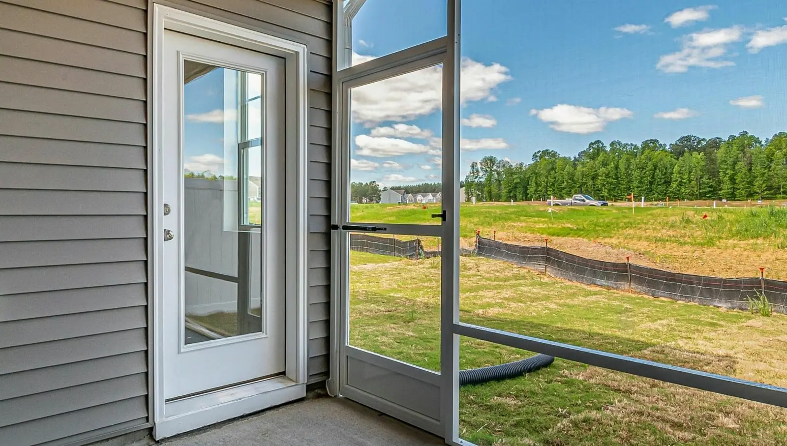 Glass storm door with view of construction site and residential development in rural Ohio area