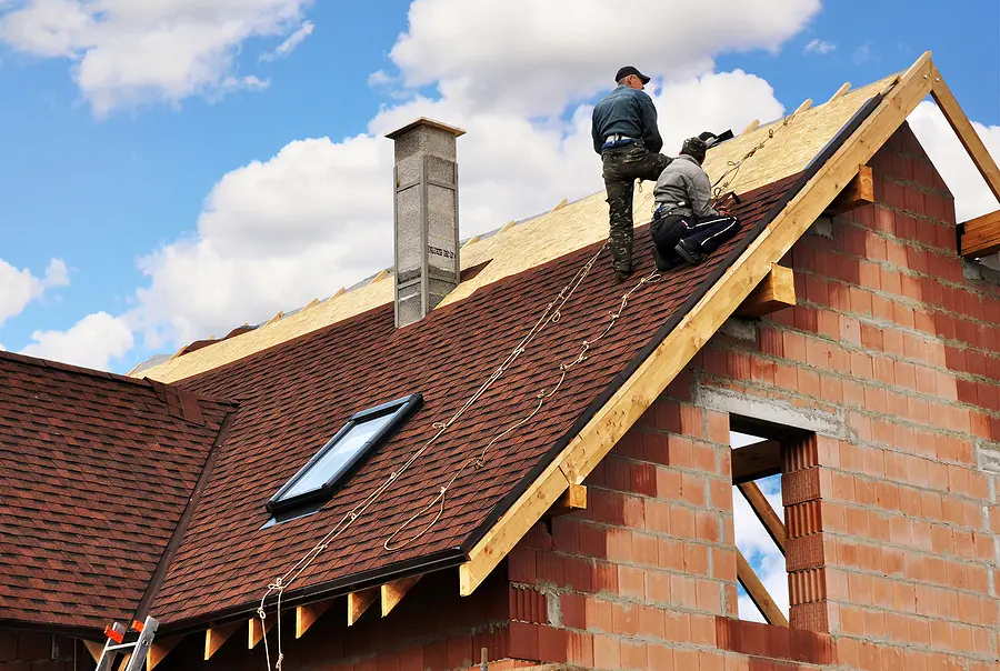 Roof replacement in Cincinnati with roofing contractors securing new asphalt shingles on a residential Midwest home