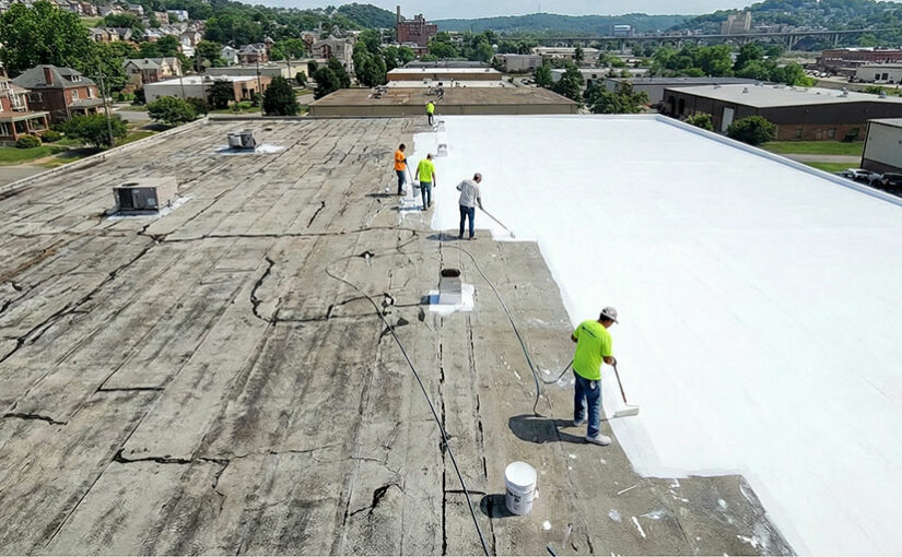 A crew applying a white silicone roof coating to a commercial building.